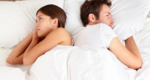 couple try to sleep in bed