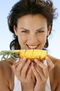 women eating pineapple
